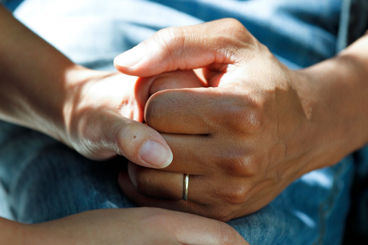A caregiver holding a patient's hands, the kind of personal attention that stops a small frustration from turning into a bad review