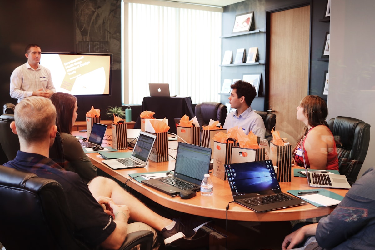 A small marketing team working together at a desk, the kind of team a medical practice weighs hiring in house versus an agency
