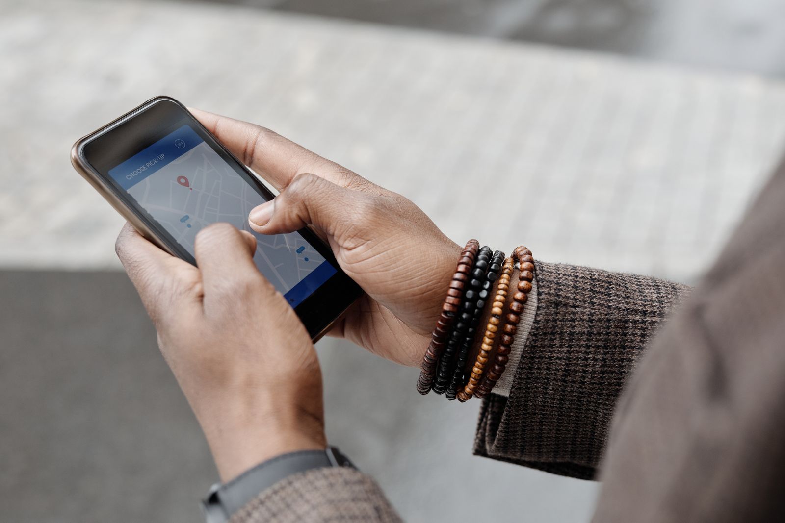Patient holding a smartphone open to a map app while searching for a local medical practice near them