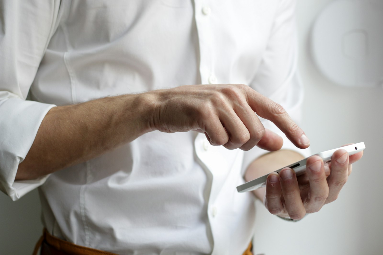 A person tapping a phone to send a text, the channel medical practices use to reach patients legally under TCPA and HIPAA rules