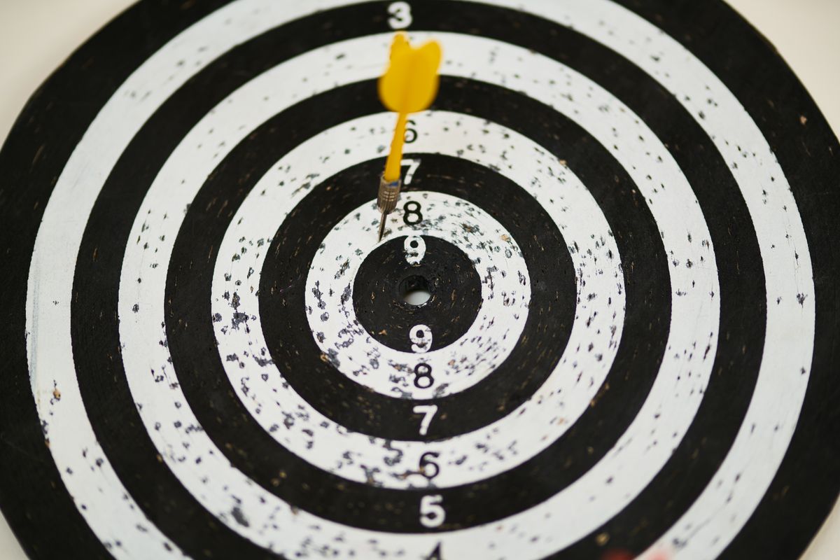 A dartboard with darts, representing a medical practice aiming its marketing at the right patients instead of everyone