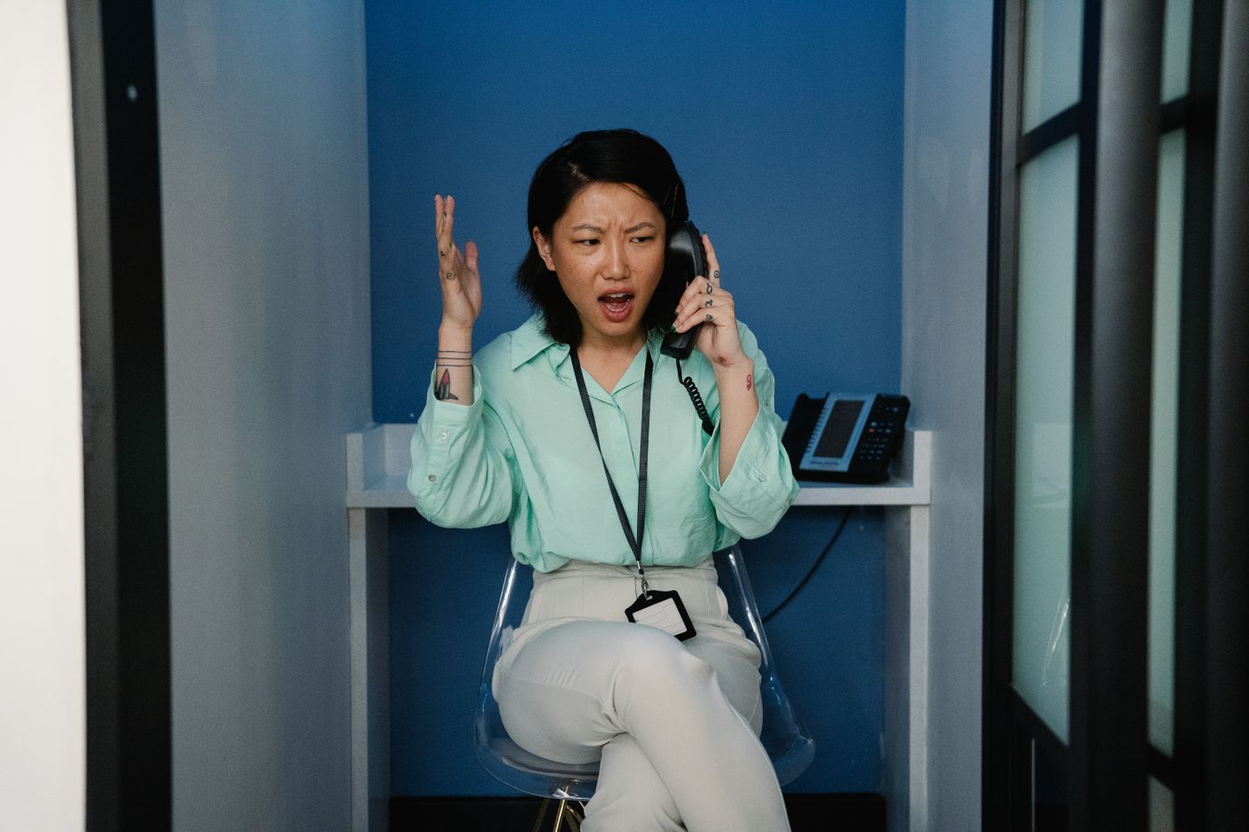 A woman looking frustrated while holding her phone during a call, the feeling patients get stuck in a medical practice phone tree