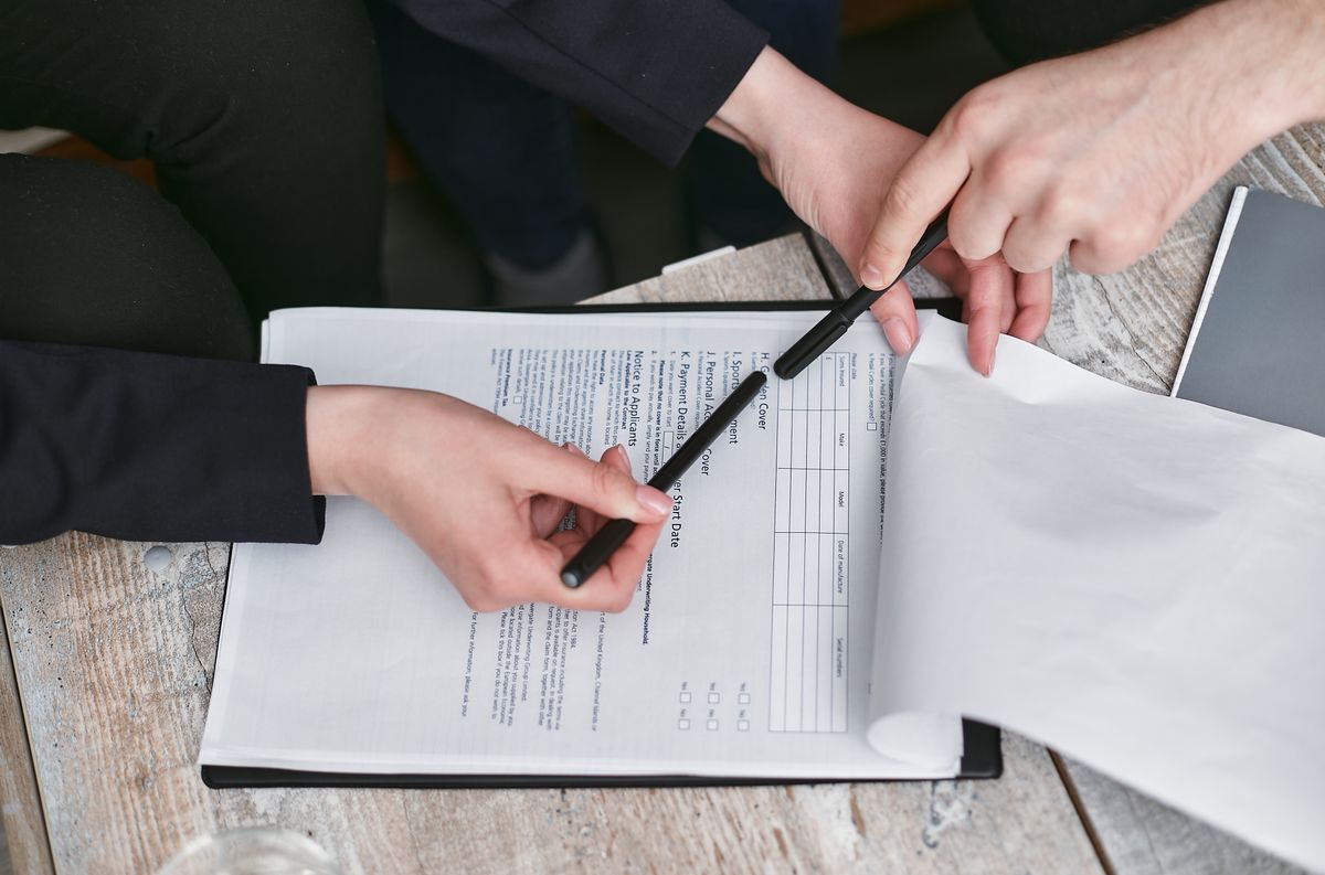 Two people reviewing an insurance policy form with a start date, the kind of choice millions make during open enrollment before finding a new in network doctor