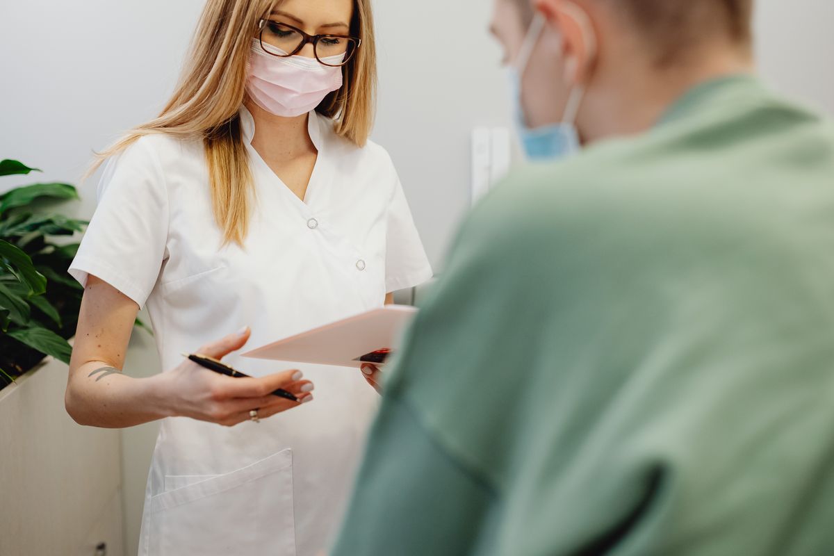 A medical staff member at a practice reception desk, where patient access is won or lost every day