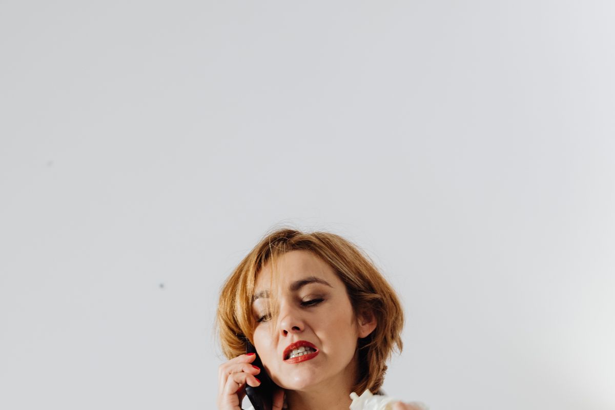 A frustrated patient waiting on hold while trying to reach a medical practice by phone