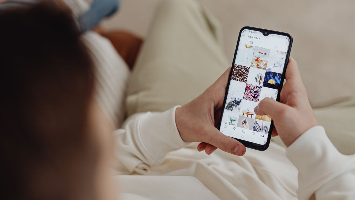 A patient scrolling a social media feed on a phone, where much of the health advice they trust now comes from before they ever call a medical practice