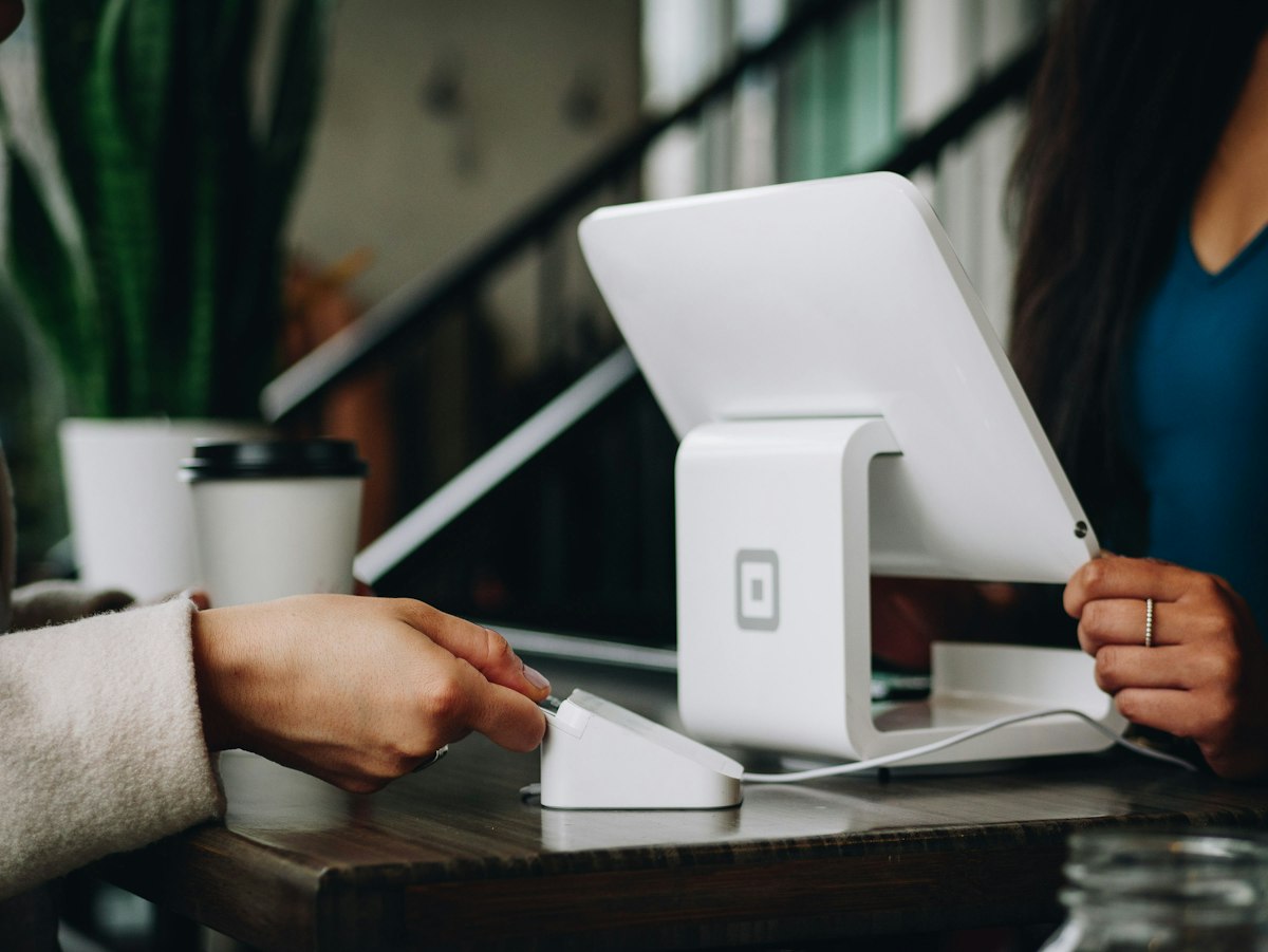 A customer paying at a modern retail checkout, the kind of fast easy experience patients now expect when they shop for a doctor