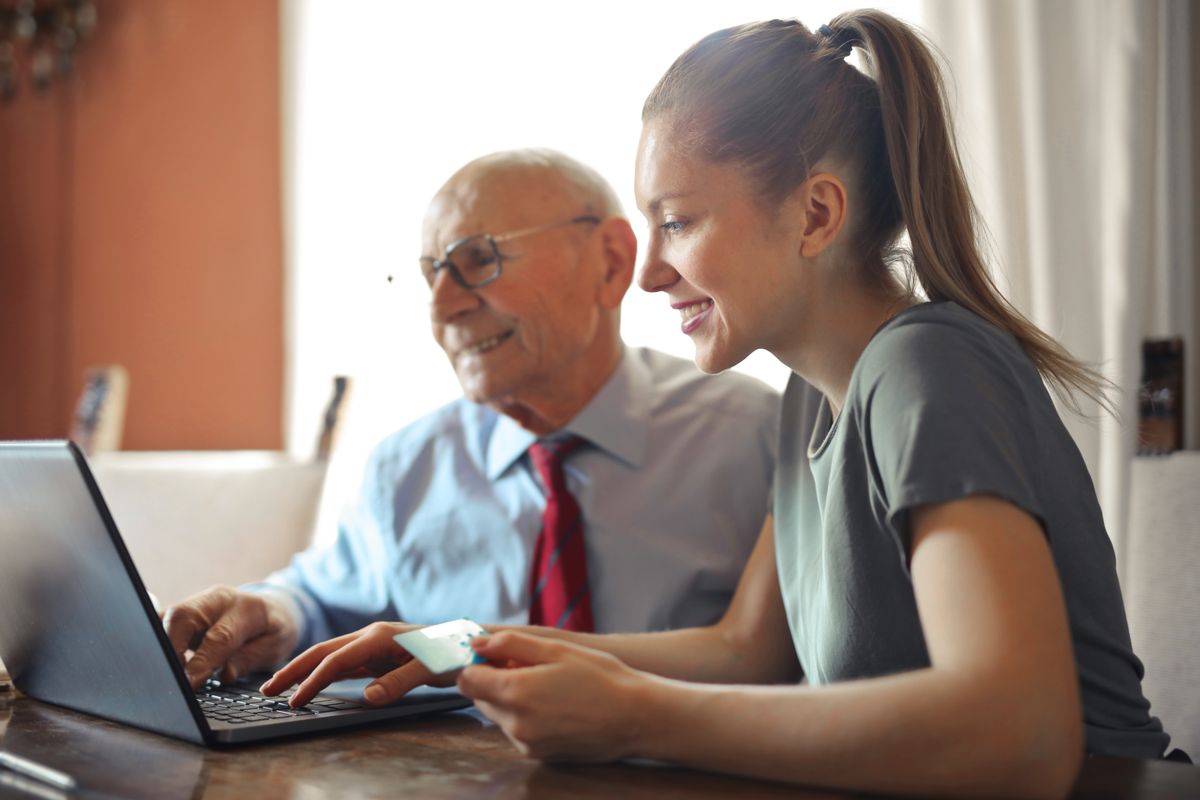 An older patient and a family member researching a doctor online together on a laptop, the new way many people choose a practice