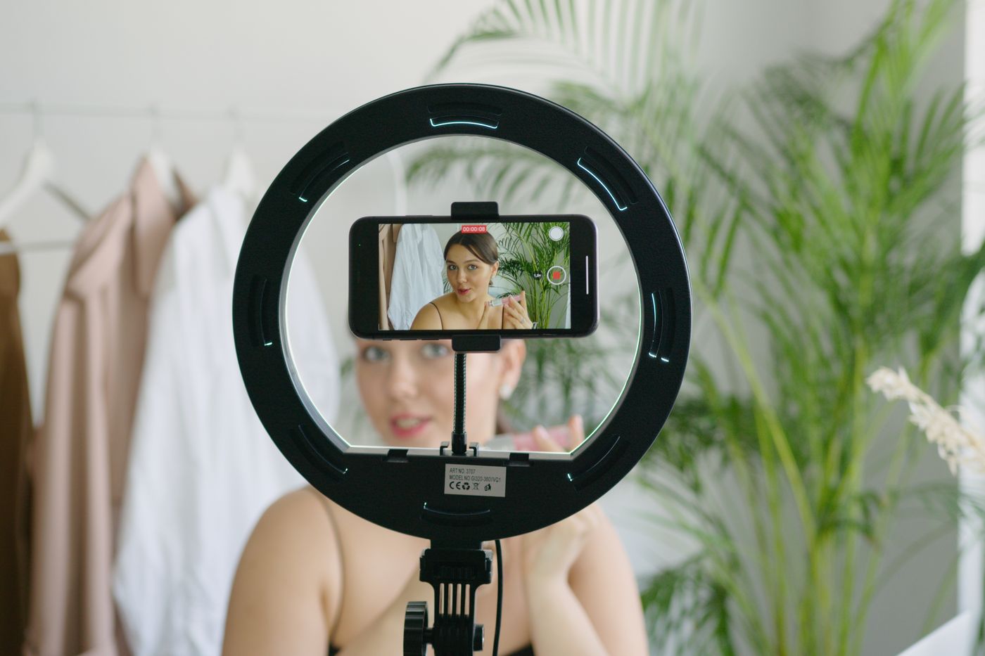A person filming a short social media video on a phone with a ring light, the kind of simple setup a doctor can use to show their face online