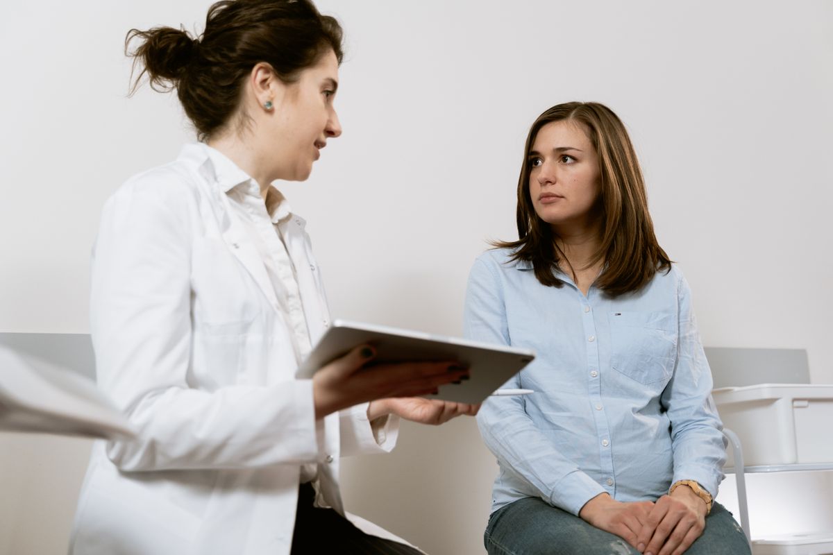 A doctor calmly explaining an answer to a patient, the same trusted way a practice can answer common health questions on social media