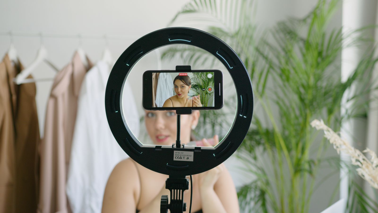 A real person filming herself on a phone with a ring light, showing authentic face forward content that healthcare ads need
