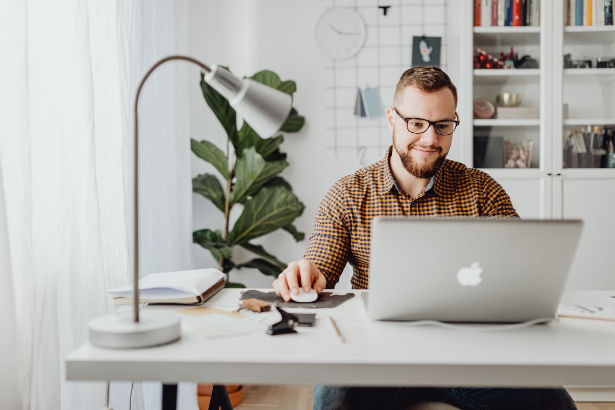 Man at a desk searching on a laptop, the kind of patient who finds a medical practice through Bing, ChatGPT or Copilot