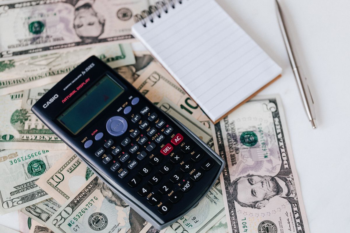 Cash, a calculator and a notepad on a desk, the old way patients pay a medical bill before a practice offers online bill pay