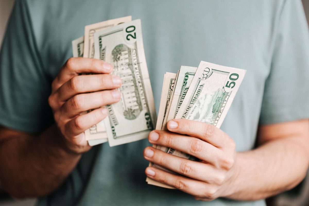 A patient counting cash, the kind of moment that decides whether a person can afford to book treatment at a medical practice