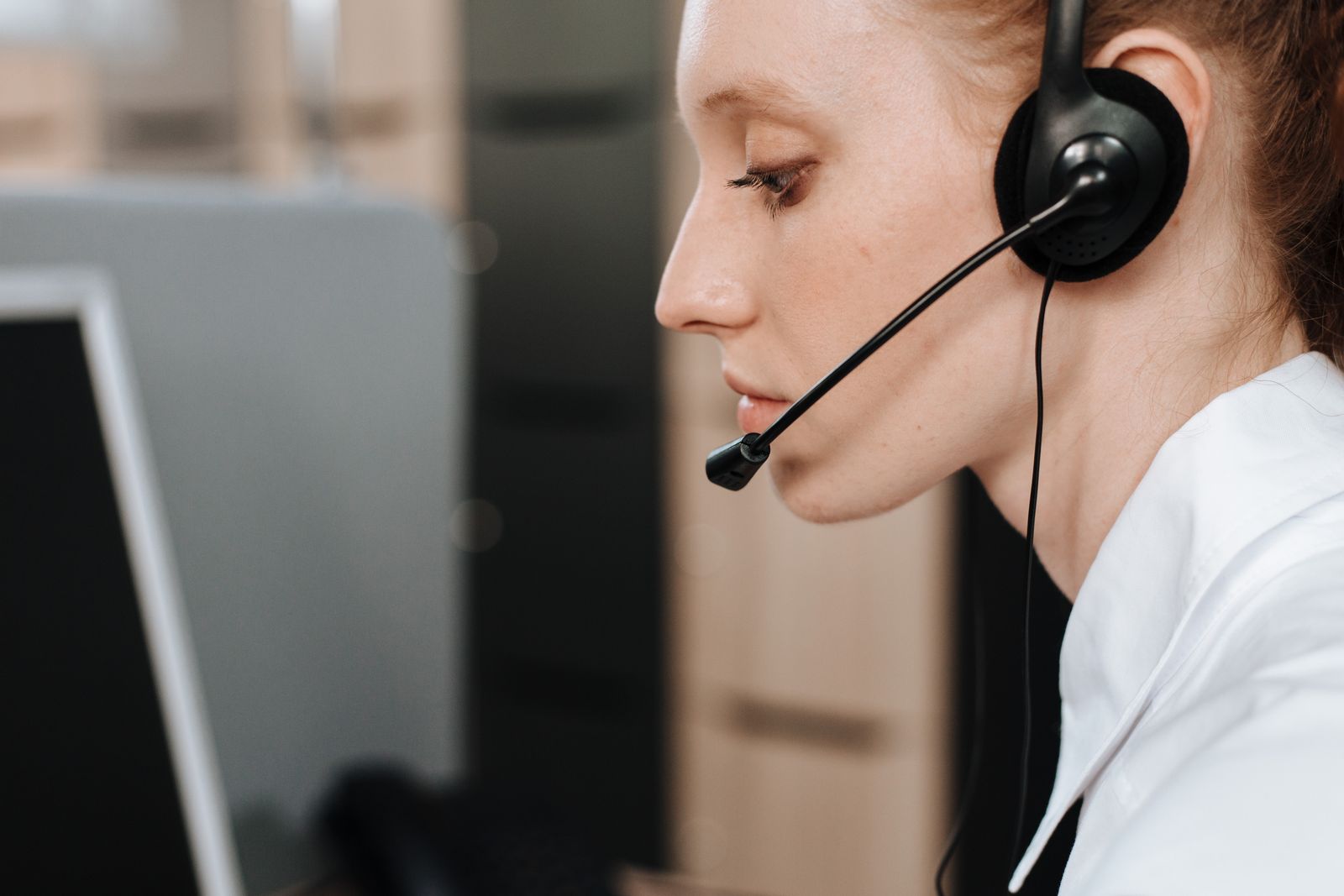 Medical practice front desk staff member taking a patient phone call on a headset