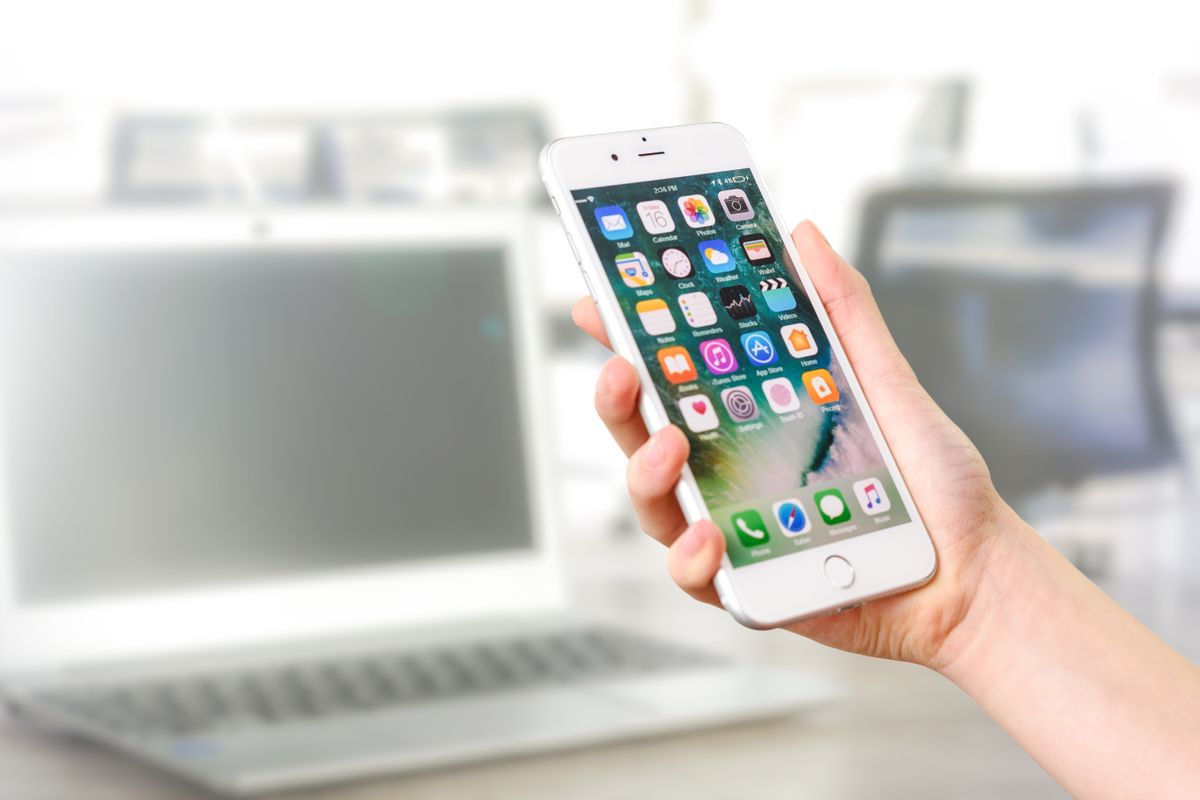 Patient holding a smartphone about to message a medical practice from a Google listing