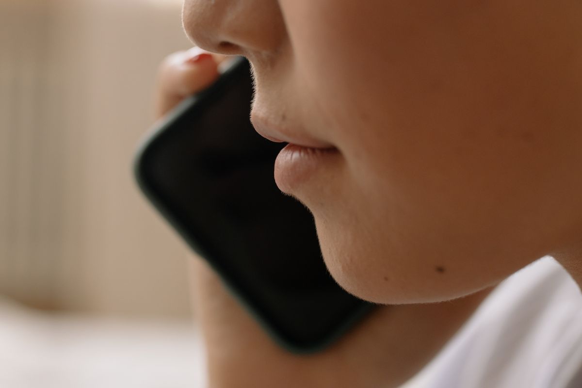 A patient on a smartphone calling a medical practice and listening to a phone menu