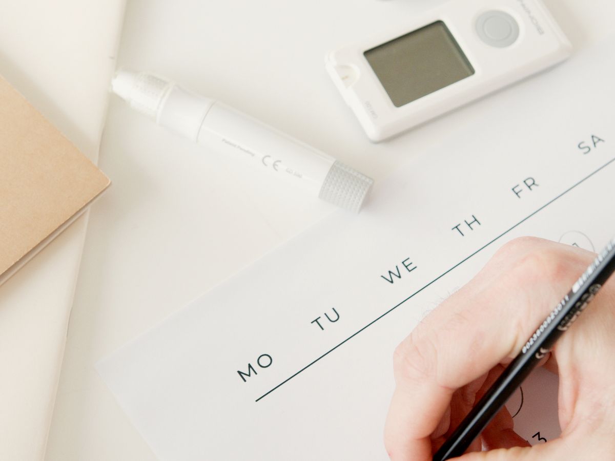 A person scheduling an appointment on a calendar with a smartphone, representing a patient choosing a doctor while booking online with a medical practice