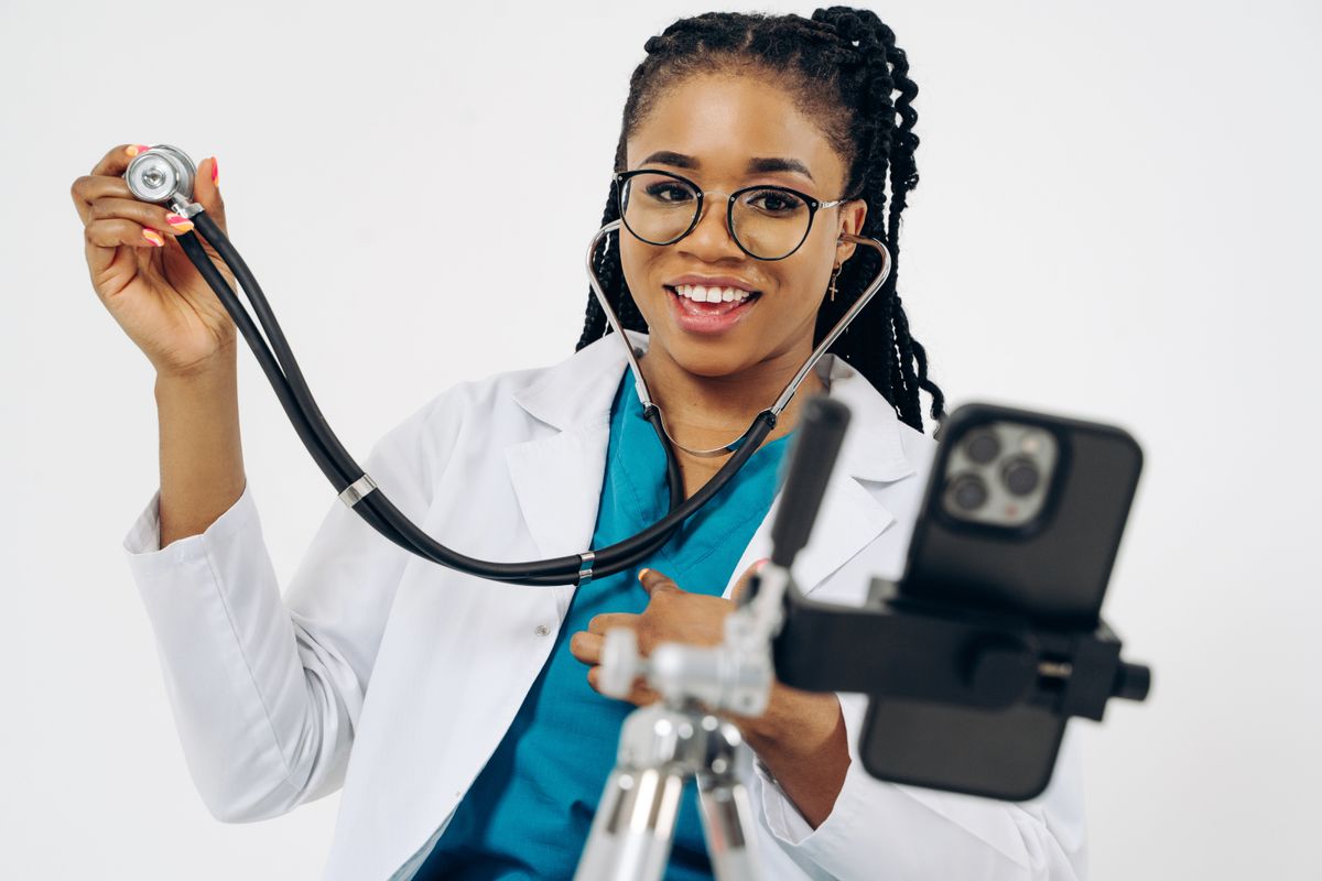 A doctor in a white coat recording a short video on a smartphone, being the face of the practice on social media