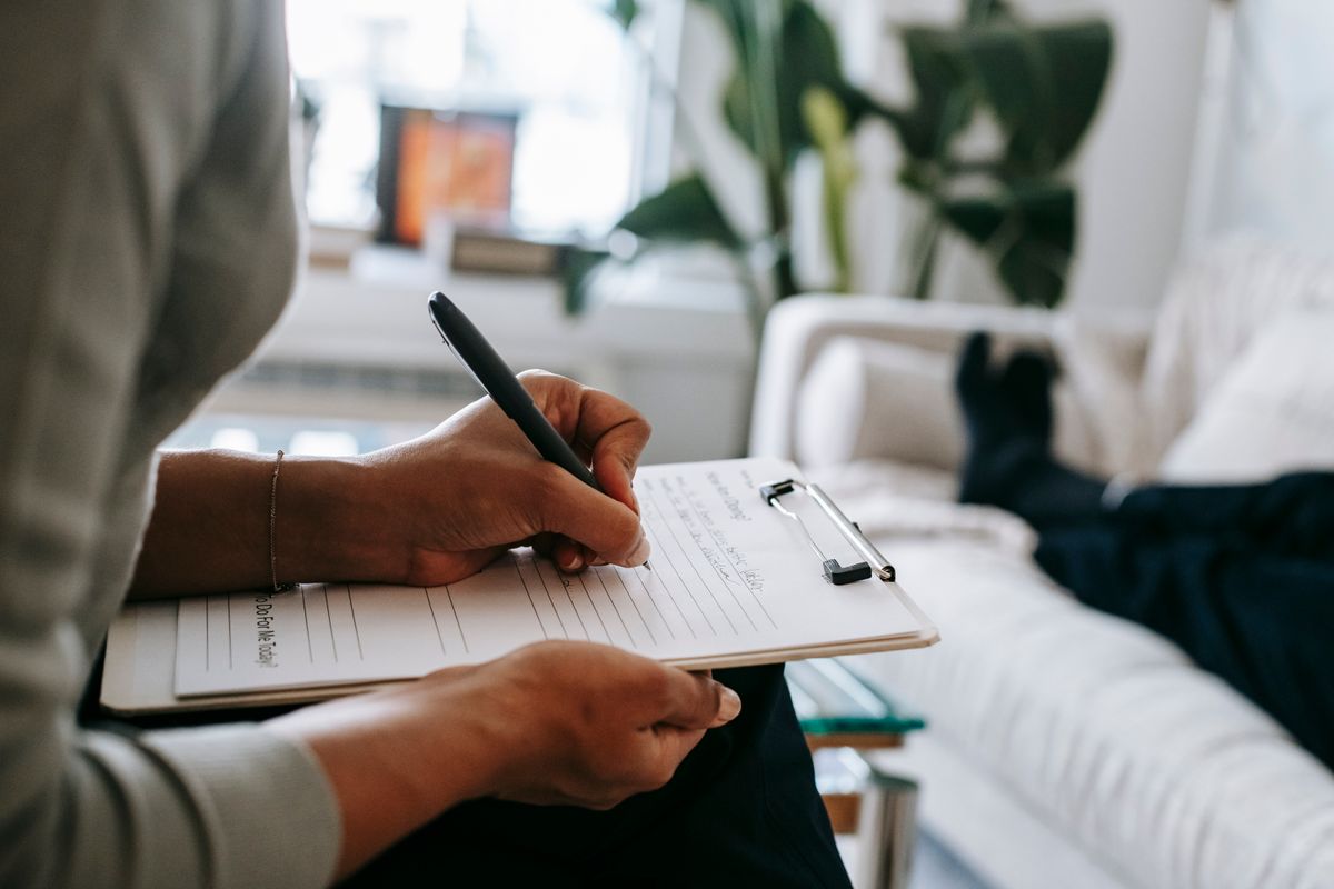 A therapist sitting with a client in a calm office, the kind of full caseload every private practice wants to keep steady