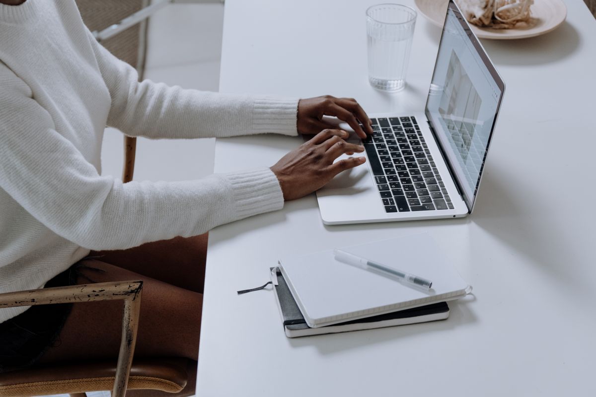 Patient filling out an online new patient booking form on a laptop, deciding whether to hand over personal information like a Social Security number