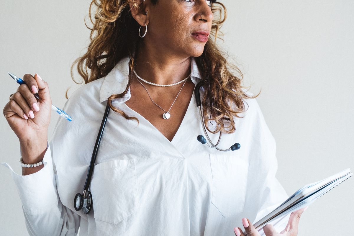A doctor smiling at the camera, the human face patients connect with before they trust a practice brand