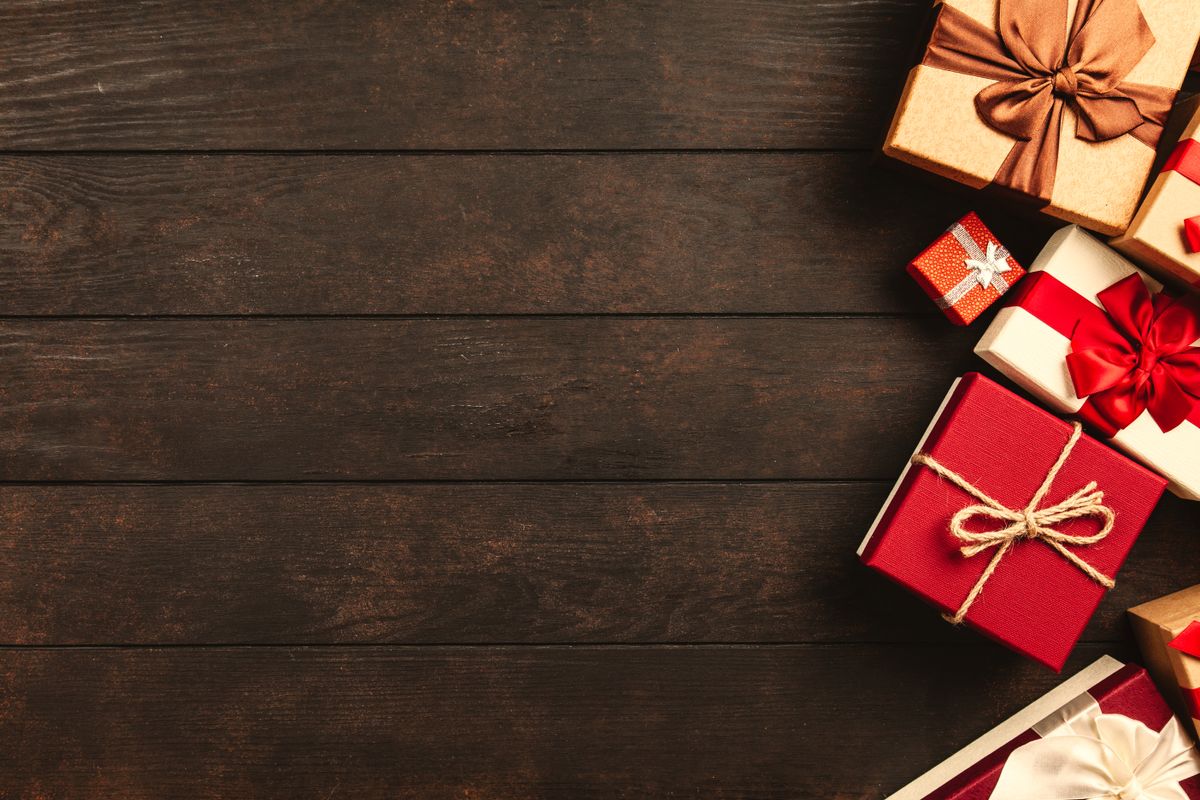 Wrapped holiday gifts on a dark wooden desk, illustrating whether a medical practice should pause its ads over the holidays