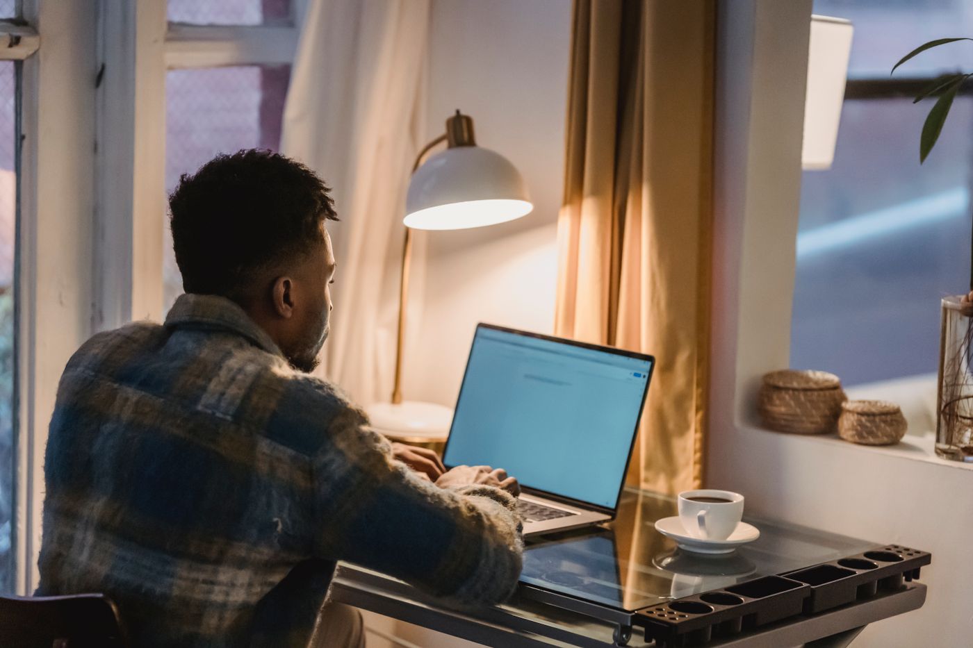 A person at a laptop in the evening researching a doctor with an AI search engine before booking