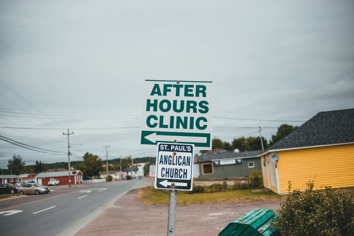 Roadside sign pointing to an after hours clinic in a small town, showing how patients look for medical practices open beyond the usual nine to five