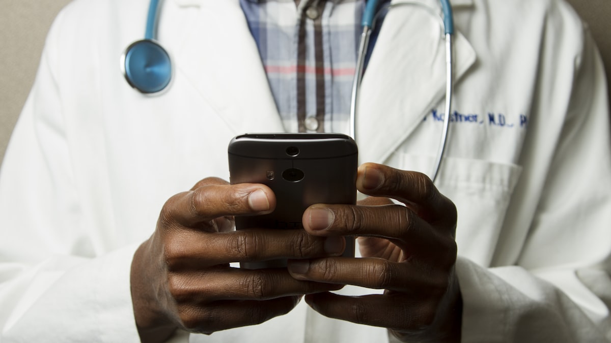 A patient viewing a medical practice website on a laptop, checking services, reviews and how to book