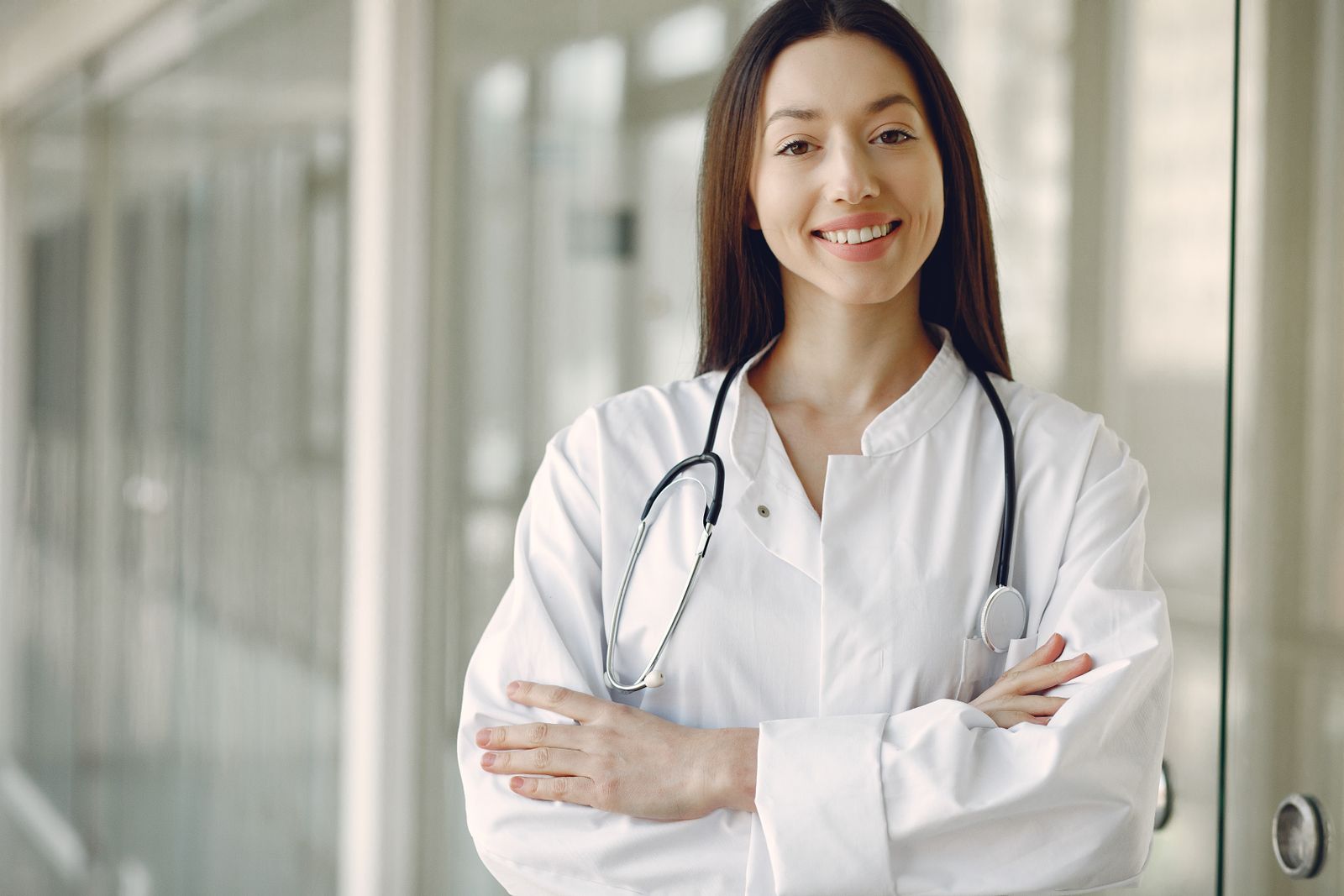 A smiling doctor in a clinic hallway, the kind of real photo that makes a medical practice about page feel human and trustworthy