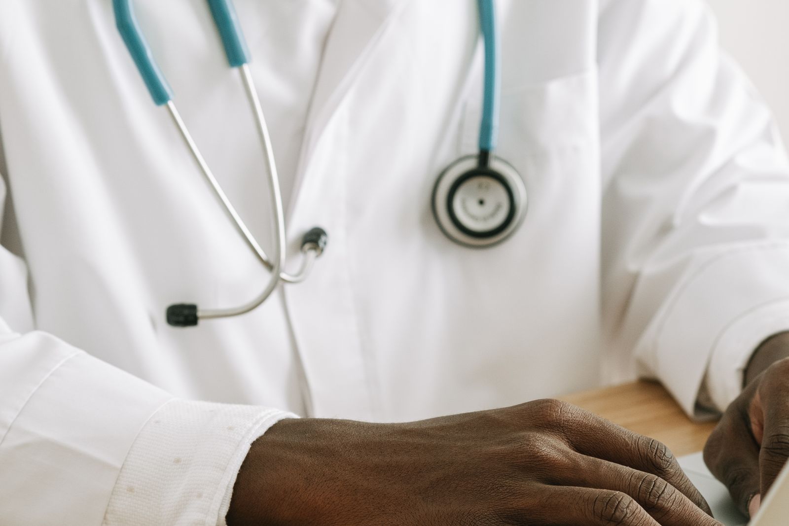 A doctor typing on a laptop, reviewing what should be on a medical practice homepage