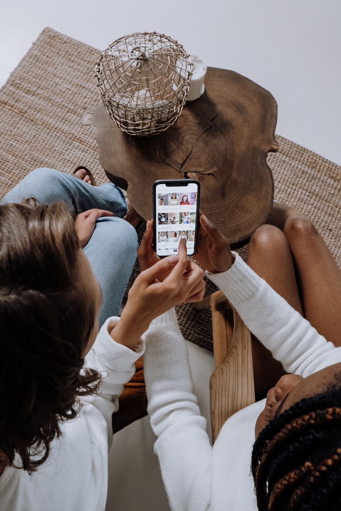 Two people looking at a social media feed of photos on a phone, the way patients scroll before choosing a medical practice