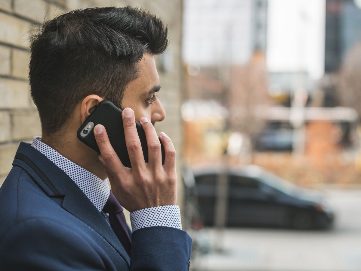 A person making a phone call on a smartphone, the way a patient or a patient's AI assistant would call a medical practice