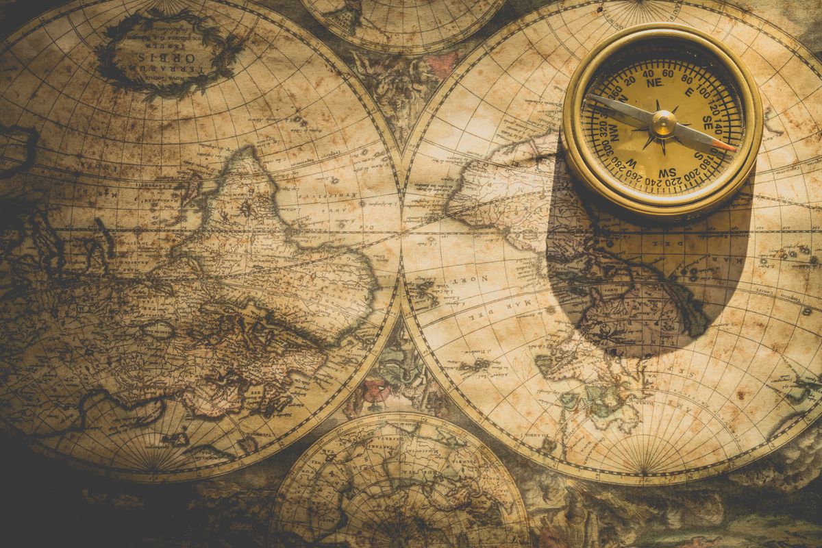 A brass compass resting on an old world map, representing how a medical practice finds the right place to start with marketing