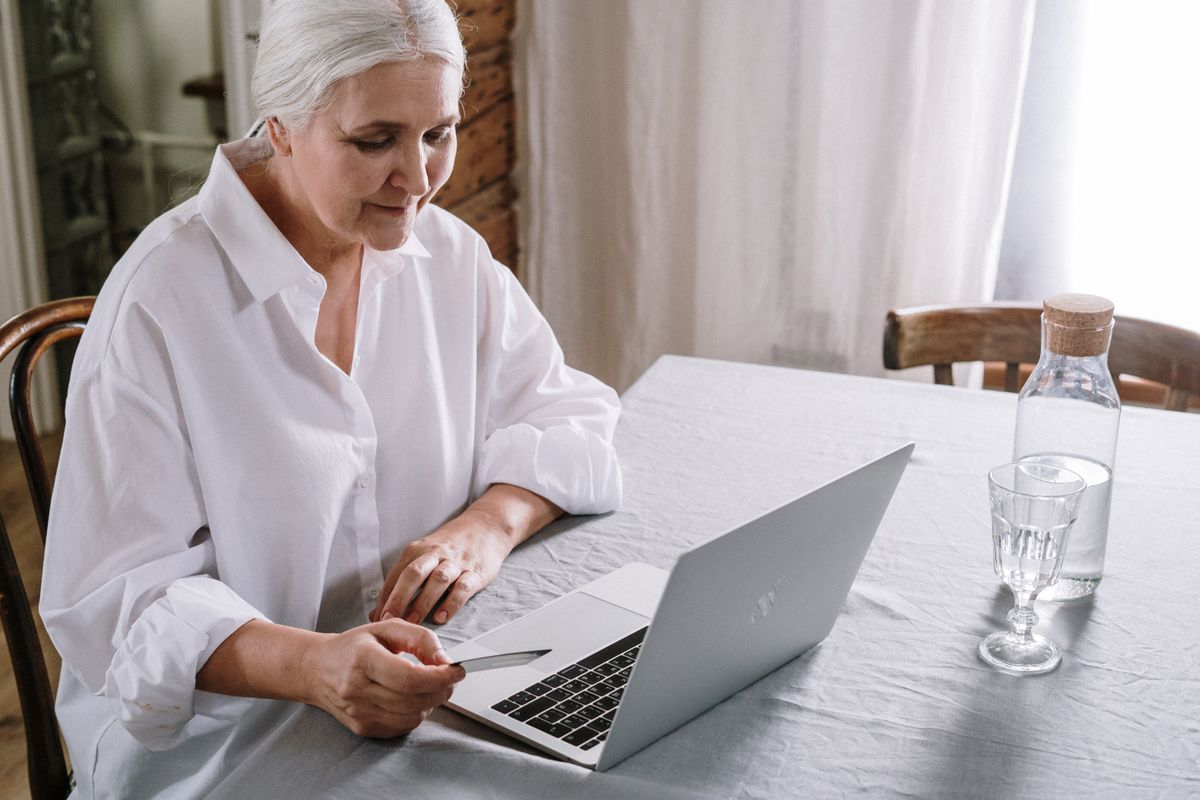 Older woman using a laptop at home, representing the 45 to 60 patients who use AI to find a doctor