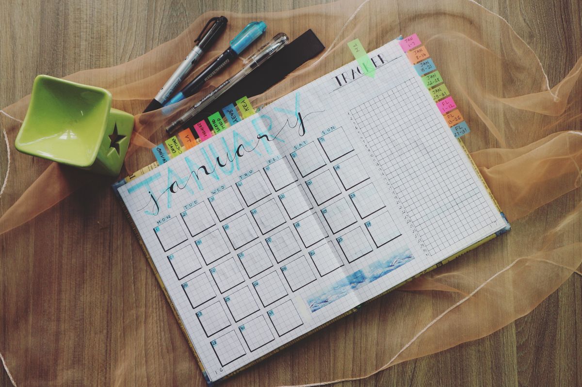 A hand lettered January planner page with colored tabs, representing the new patient surge medical practices see each January