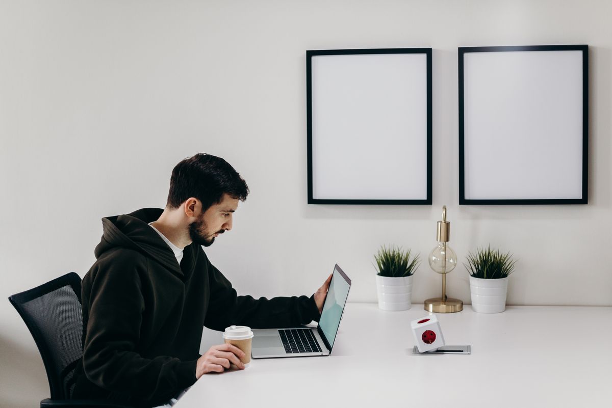 A patient sitting at a laptop with coffee, researching and comparing doctors online before deciding whether to switch providers