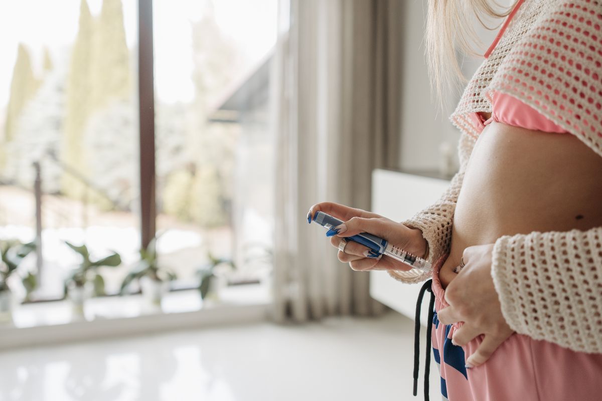A patient injecting a GLP-1 weight loss pen at home, the moment a clinic either keeps them or loses them