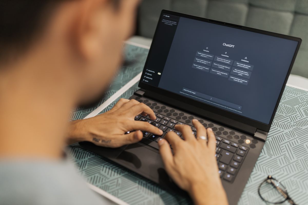 A person using ChatGPT on a laptop to write content, representing a medical practice weighing AI content against its SEO and Google ranking